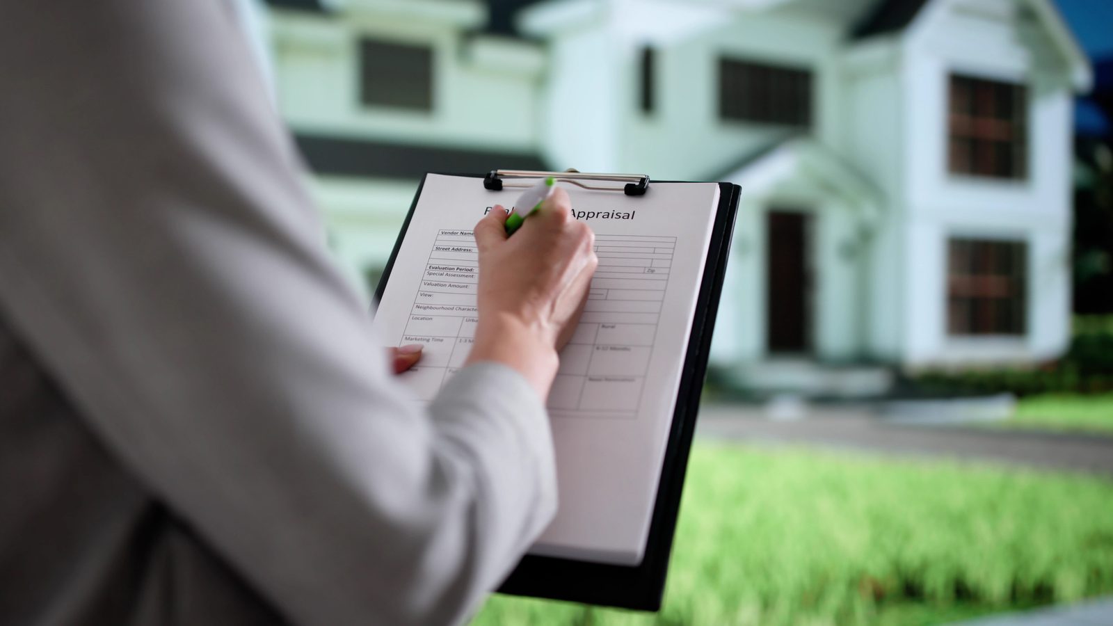 An appraiser completing a real estate appraisal form outside a house